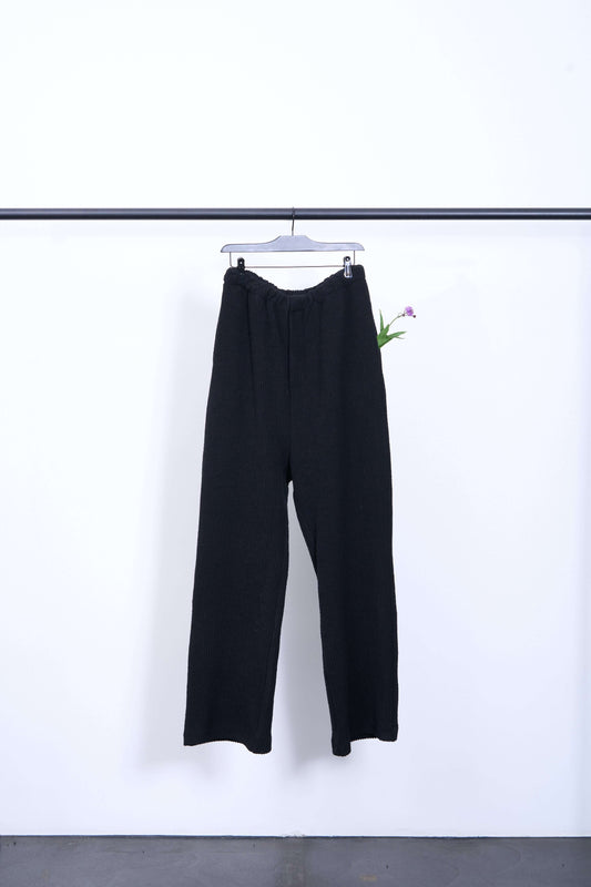 WOOLY OVEN TRACK PANT displayed on hanger, made from boucle ribbed jersey fabric, showcasing stylish design.