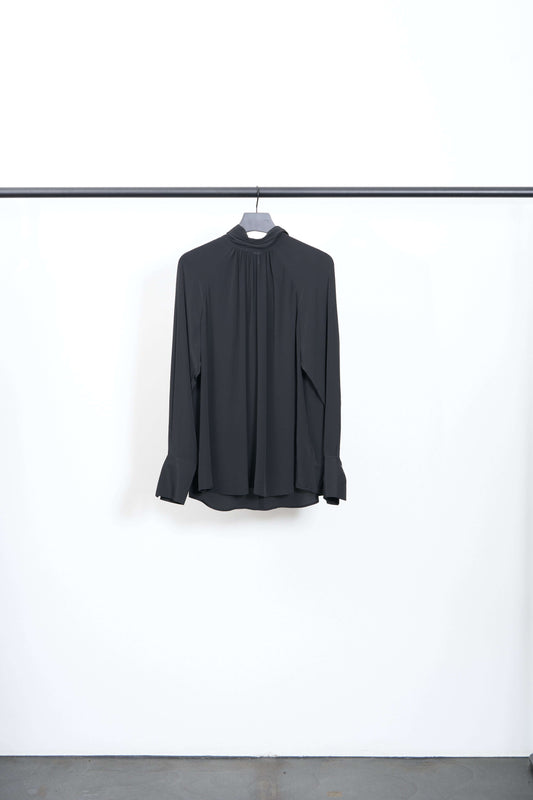 TIE NECK BLOUSE displayed on a hanger, featuring a relaxed fit and integrated neck tie detail in black.