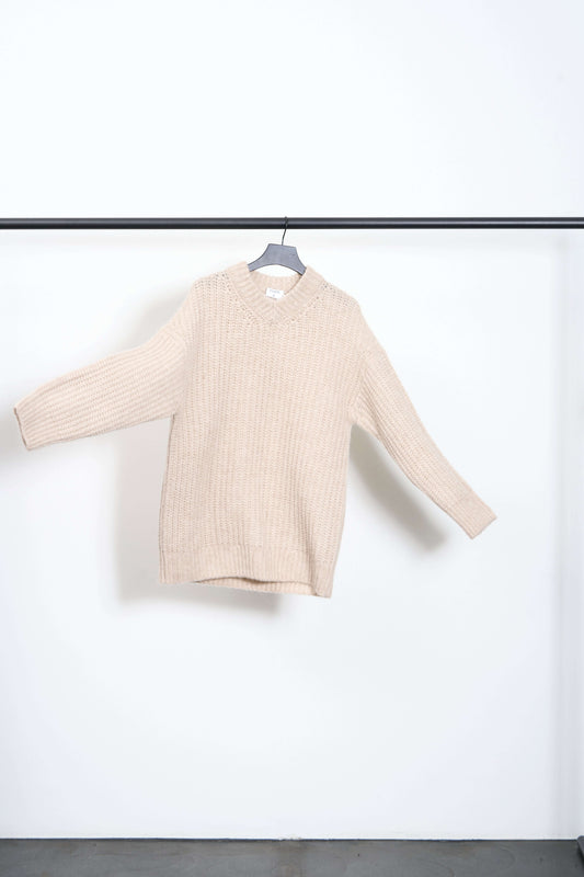SOFT ALPAKA V-NECK SWEATER hanging on a hanger against a minimalist background.