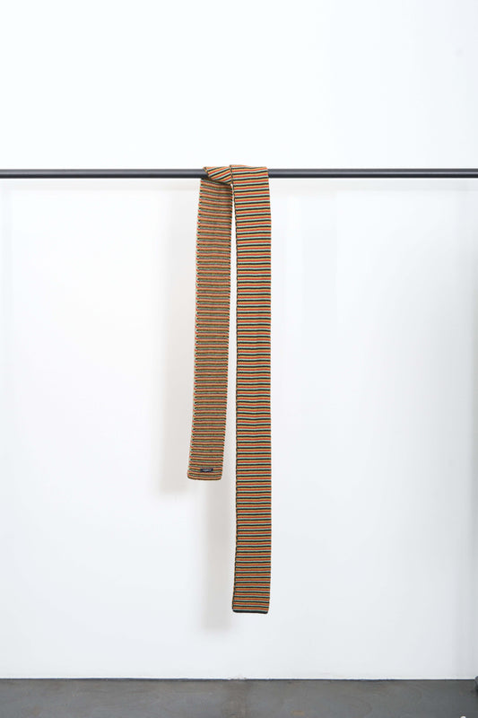 LONG MULTICOLOUR STICHED SCARF hanging on a rack, displaying narrow 4 colour stripes, made from soft lambswool.