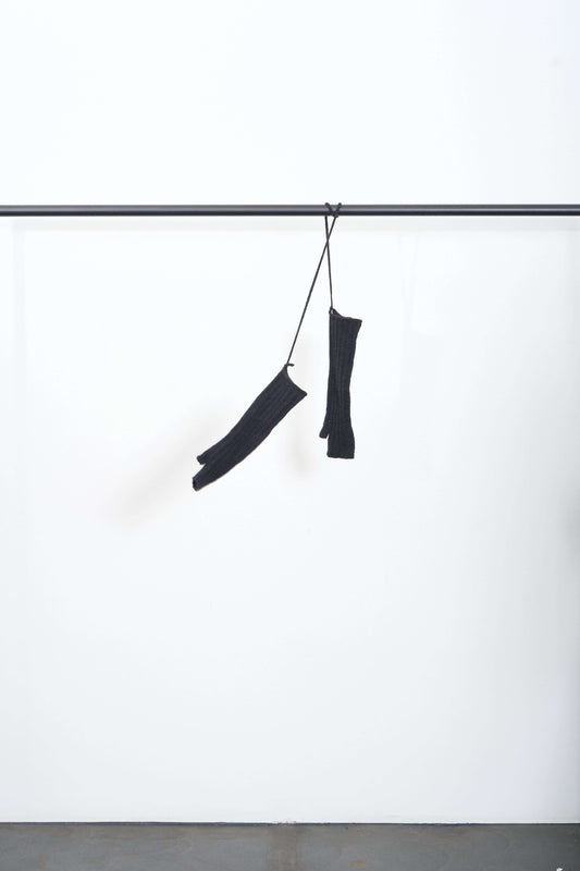 MIJIAKI MITTENS hanging on a display rack, showcasing their ribbed fingerless design and warm texture.