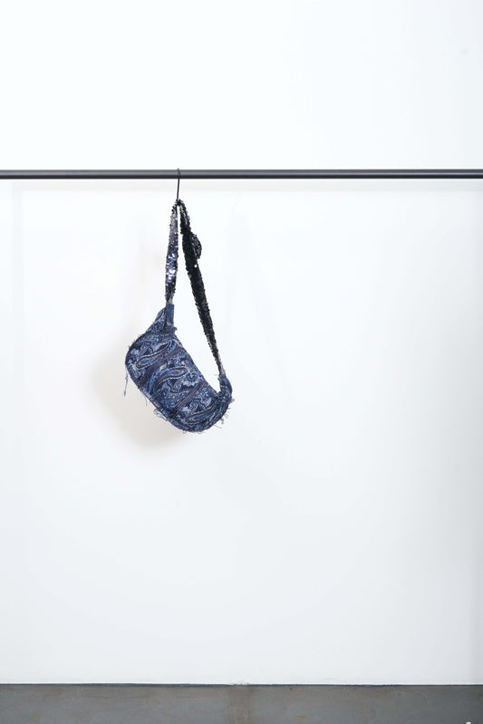 FALLAS BAG, a glamorous accessory, hanging on a display rack, featuring a unique design and stylish strap.