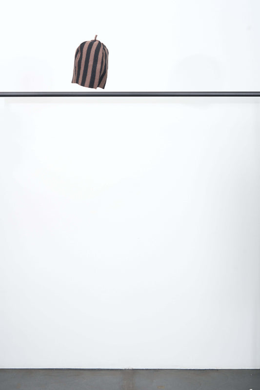 UKIYO HAT featuring a stylish striped design, made from extrafine merino wool, hovering above a minimalist backdrop.