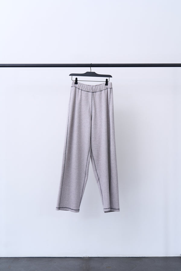 FOLD SWEATPANTS hanging on a rack, showcasing their comfortable design and contrast stitching details.