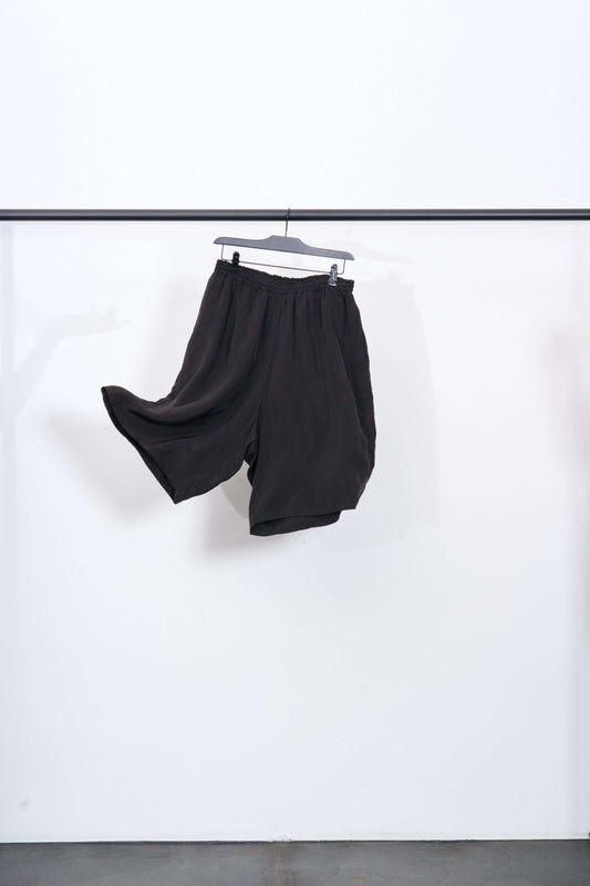 CUPRO SHORT TROUSERS hanging on a black hanger against a white background, ideal for summer outfits.