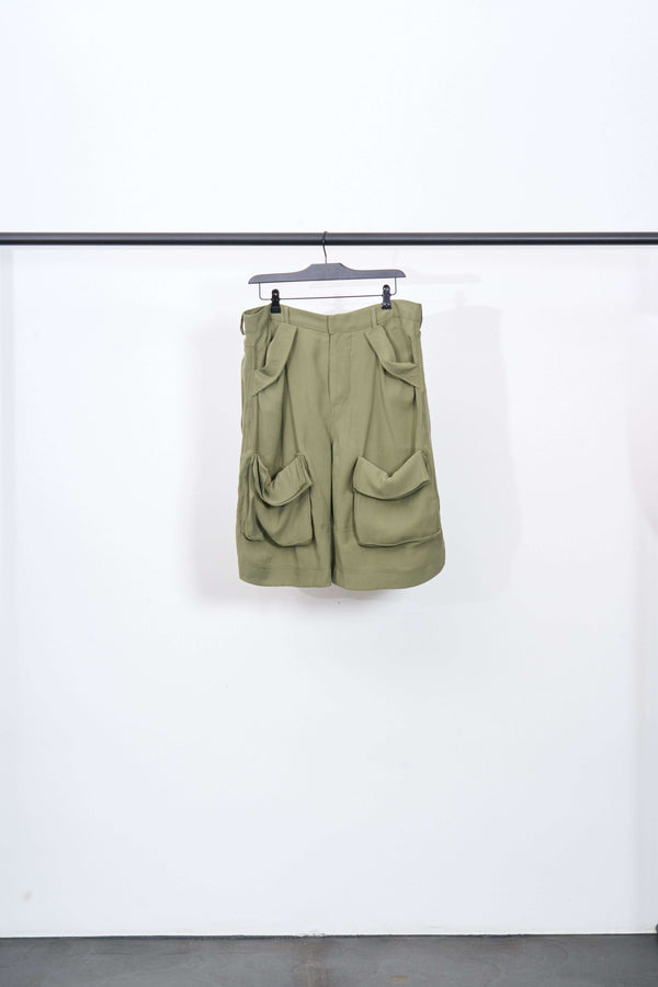 CARGO SAG SHORT in olive green, displaying its unique pocket design and brushed viscose fabric on a hanger.
