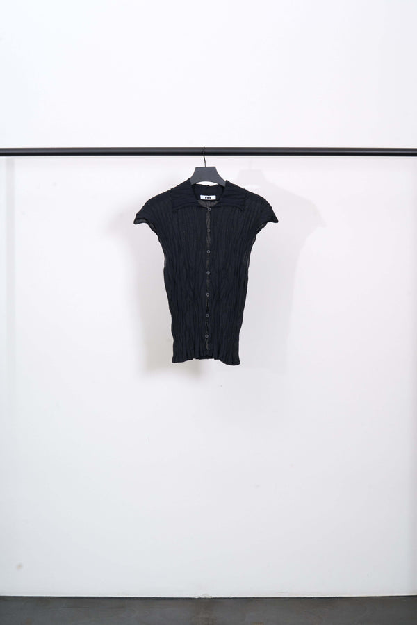HONKAI TOP in faded-black organic cotton with buttons, semi-transparent, hanging on a black rack.