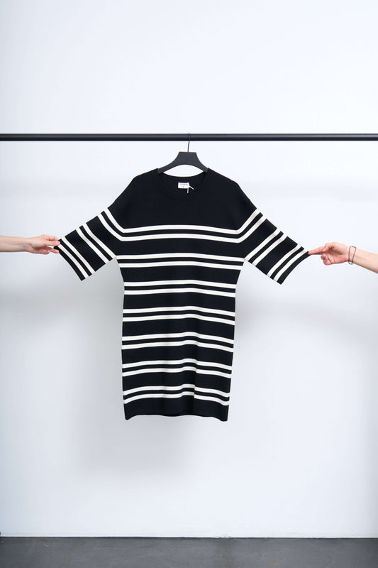 MILANO KNIT DRESS displayed on a hanger, featuring bold black and white stripes.