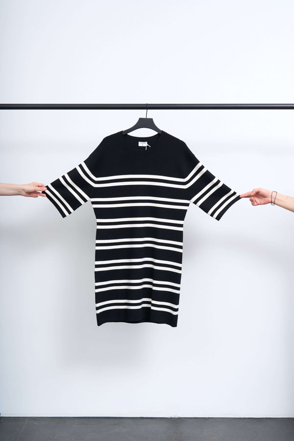 MILANO KNIT DRESS displayed on a hanger, featuring bold black and white stripes.