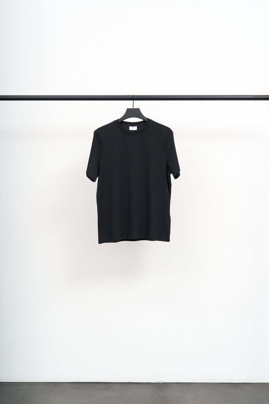 FILIPPA TEE black t-shirt hanging on a rack, showcasing a regular silhouette and soft regenerative cotton jersey.