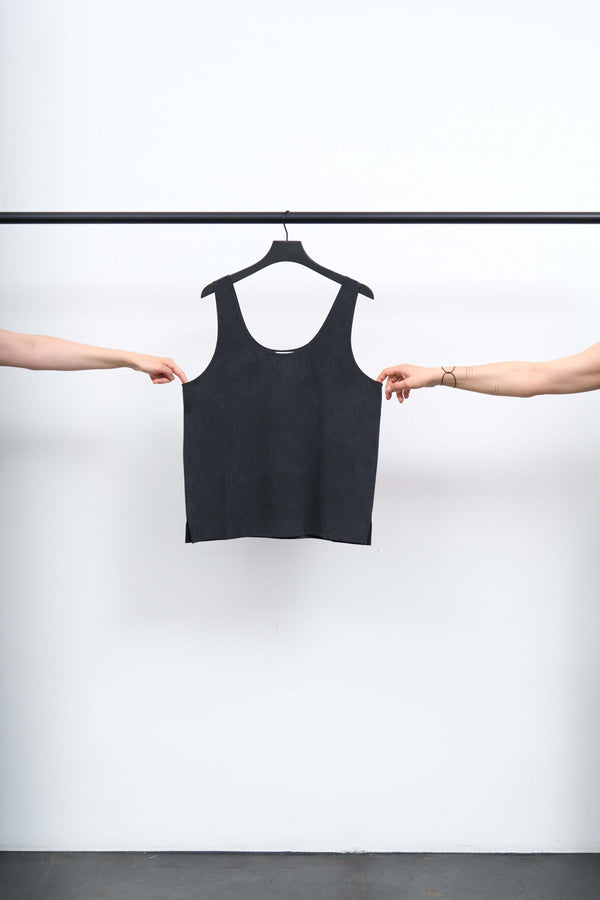 SIKA - LIGHT TENCEL SINGLET hanging from a black hanger, showcased by two hands.