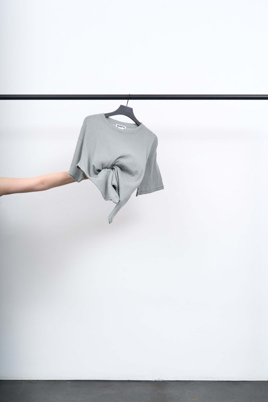 BOXY T SHIRT hanging on a rack, showcasing oversized fit and soft organic cotton fabric.
