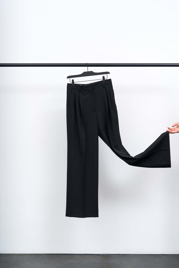 Darcey Wool Trousers showcased on a hanger, highlighting their structured design and elegant silhouette.