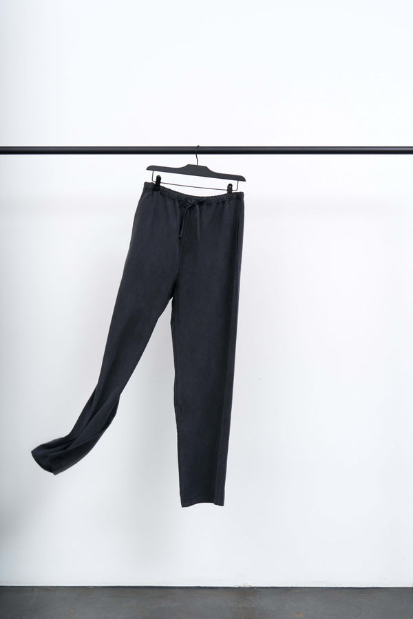 ANI - LIGHT TENCEL TROUSER hanging on a rack against a white background, showcasing its relaxed silhouette.