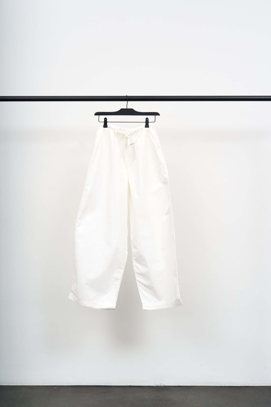 KOLLA PANTS on a hanger showcasing their wide leg and lightweight white fabric with a relaxed fit.